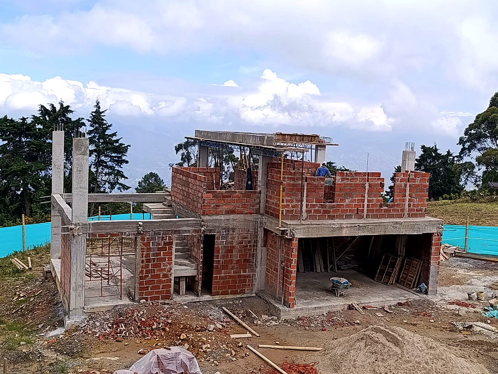 Casa en ladrillo y concreto sobre la ladera con vista al valle