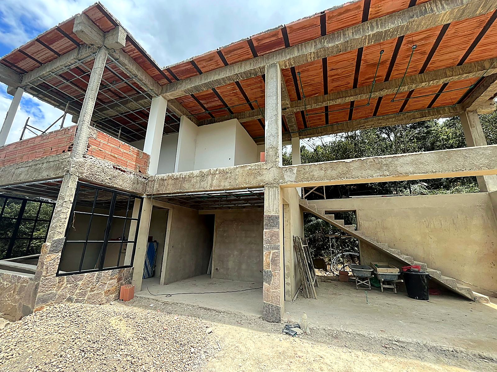 Fachada posterior con doble altura, escalera y carpintería metálica negra