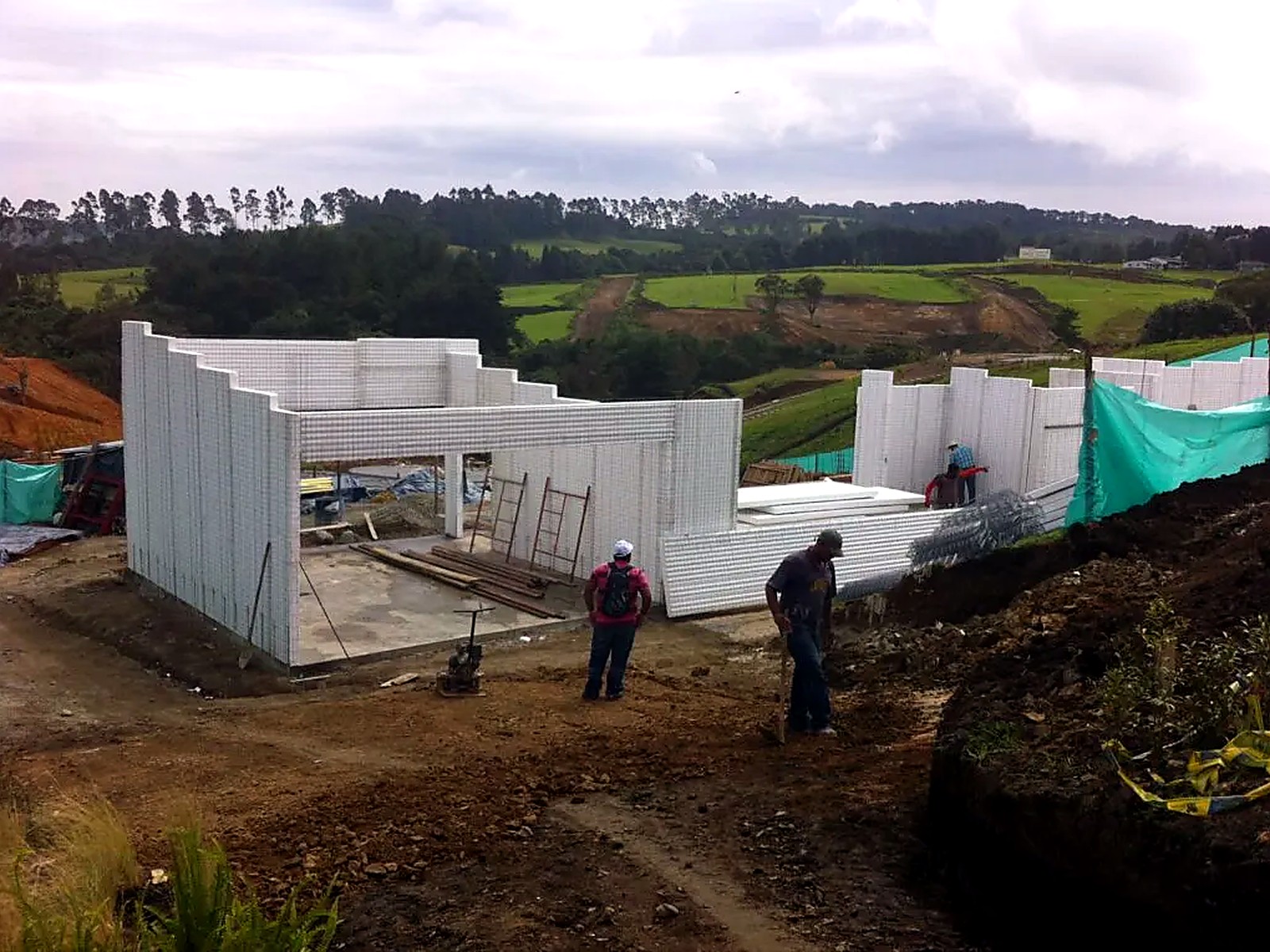 Muros en panel estructural levantados sobre la placa con malla verde perimetral