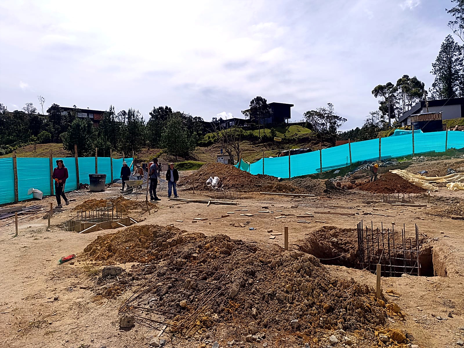 Cuadrilla y zapatas excavadas frente al cerramiento verde
