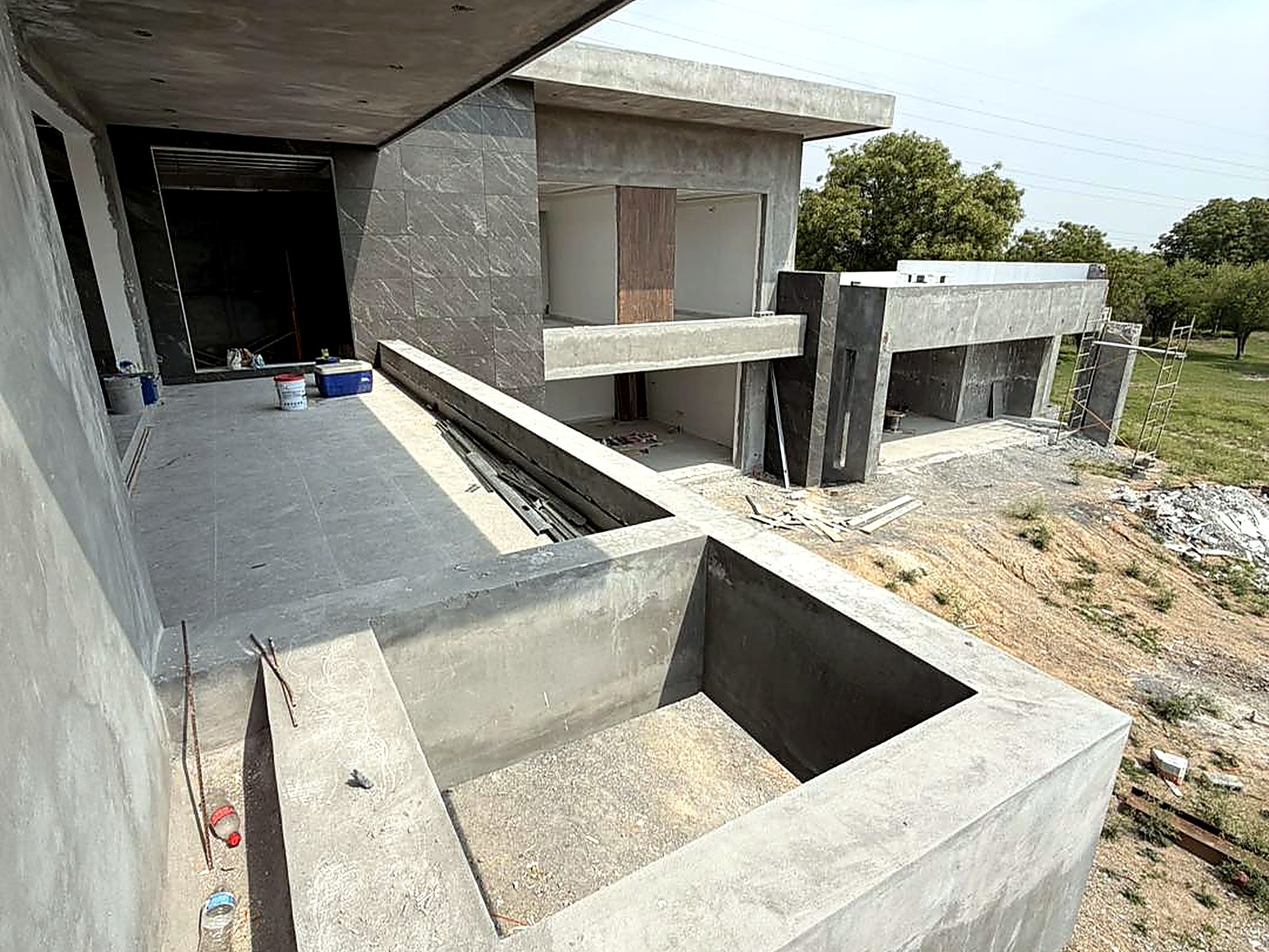 Volúmenes en concreto a la vista con piscina y terraza en obra gris