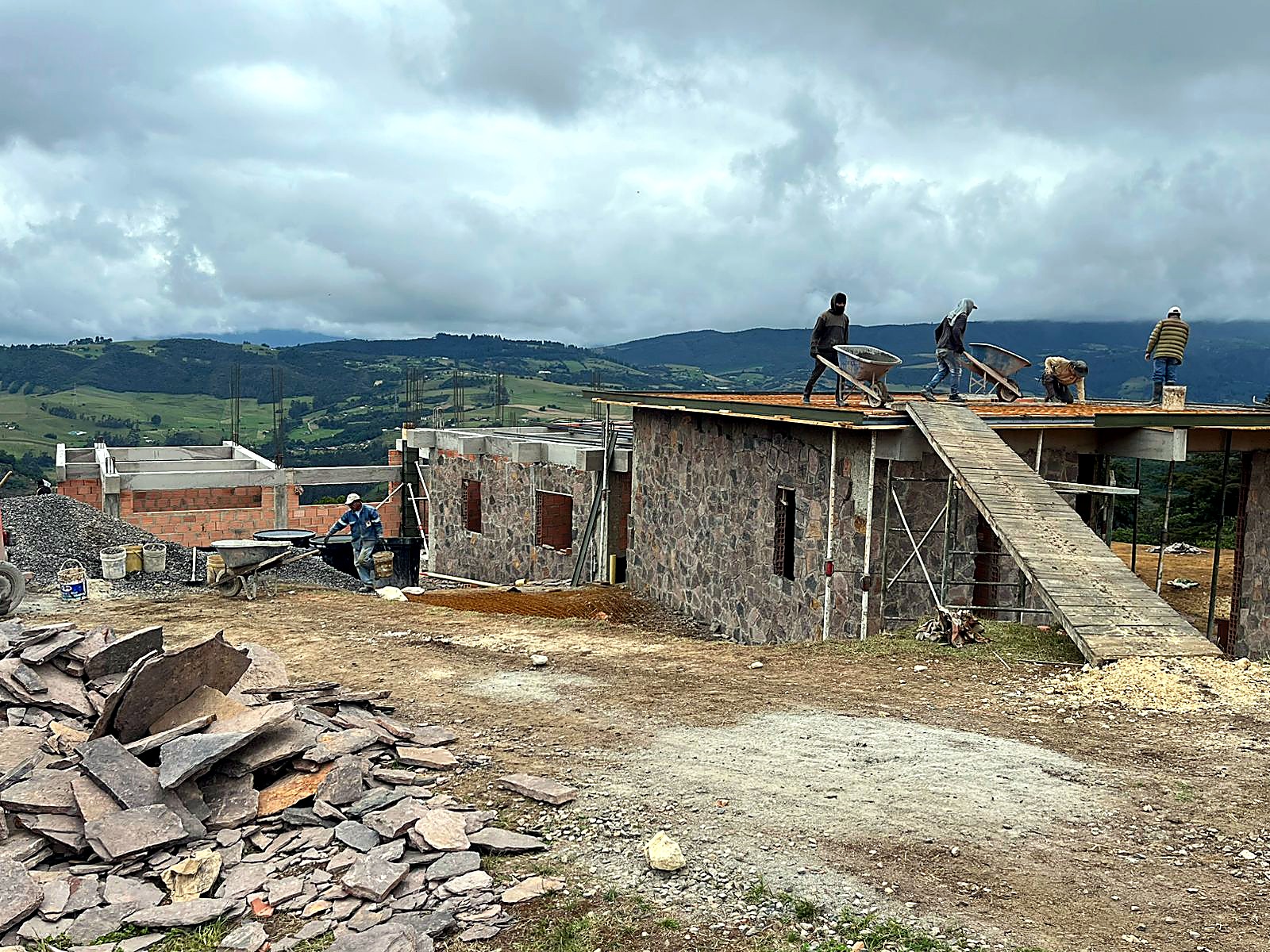 Vista general del conjunto con acopio de laja y trabajos en cubierta