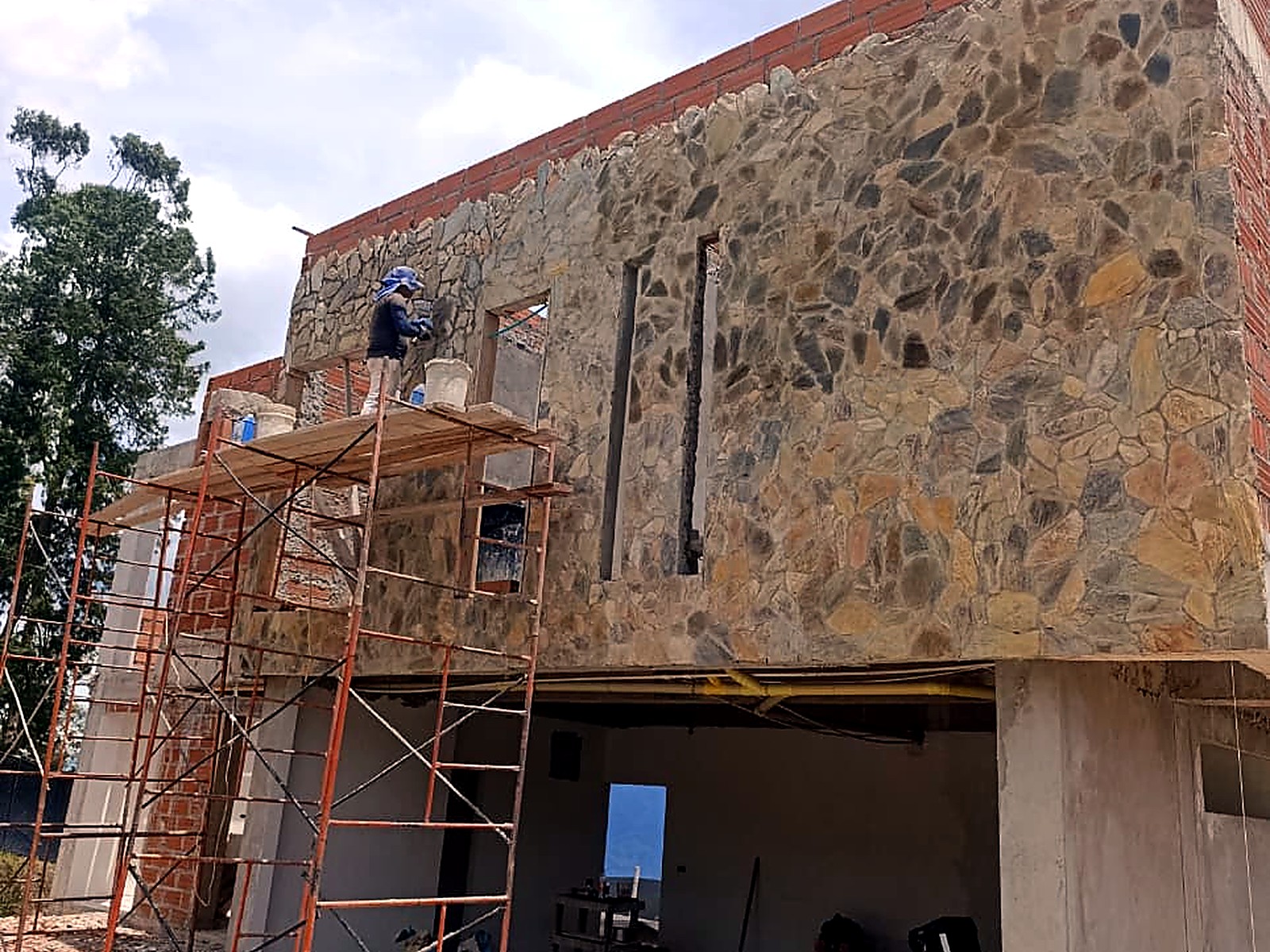Instalación del enchape en piedra desde el andamio