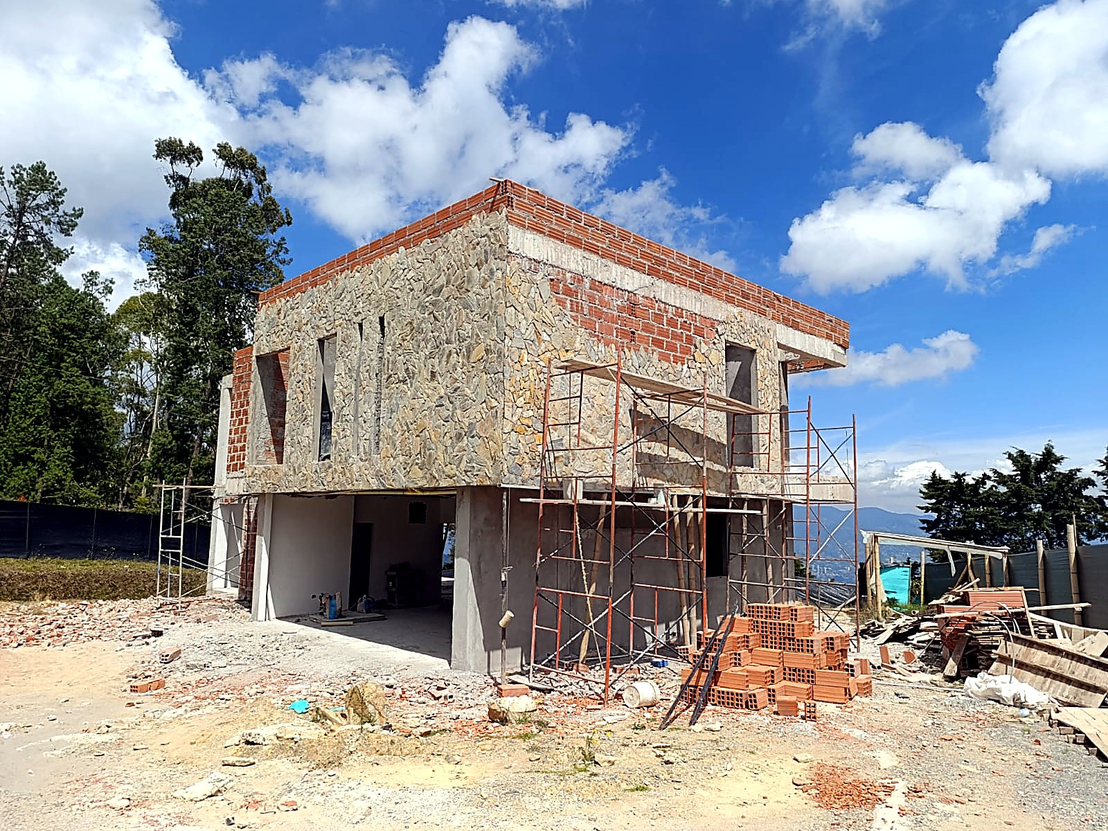 Volumen de dos pisos con fachada en piedra y remate en ladrillo