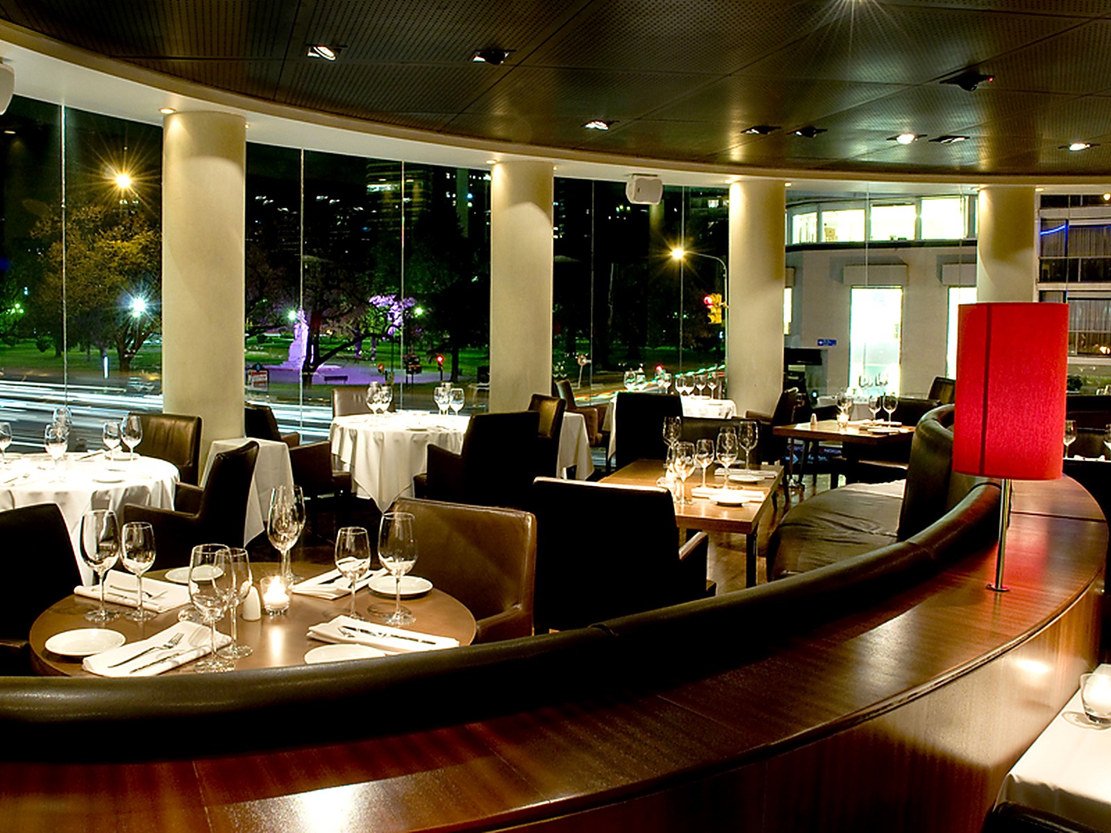 Comedor perimetral con ventanales de piso a techo hacia la avenida