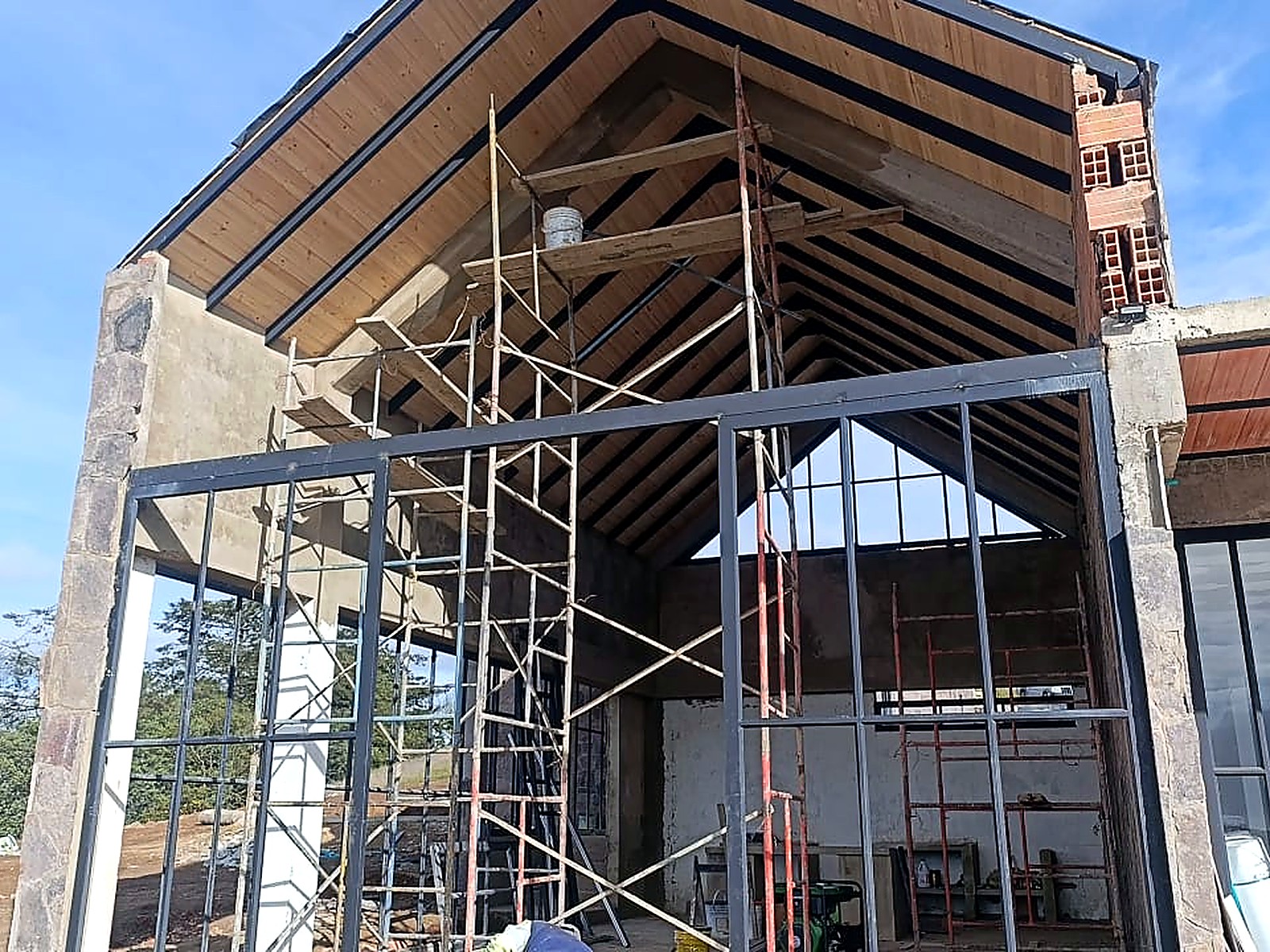 Frontón con estructura metálica y cielo raso en madera bajo la cubierta a dos aguas