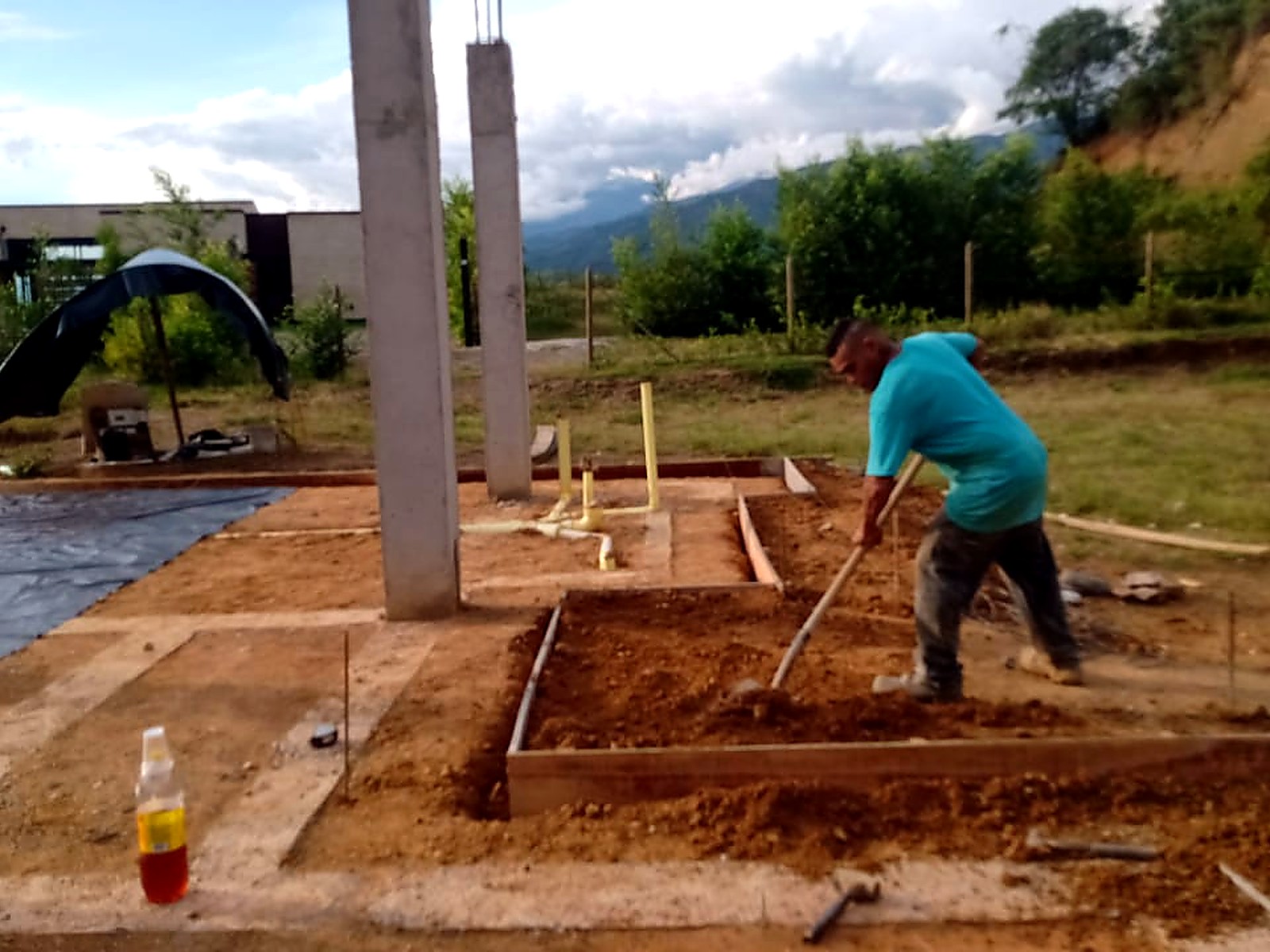 Obrero nivelando el relleno entre las vigas de cimentación