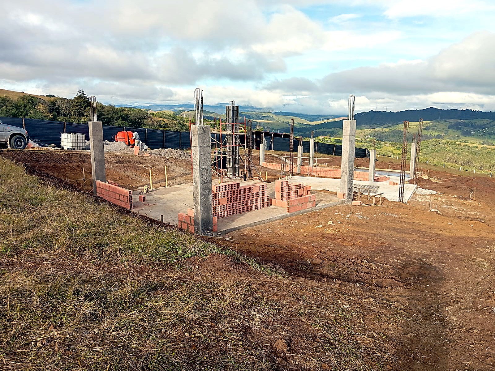 Vista general del lote con columnas fundidas y material en obra